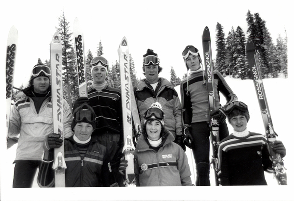 Seven skiers from ski team. Gantz (?) is lone women. Image contains the text: "DYNASTAR   ROSSFIGNOL   RAVSCOK SKI TEAM"