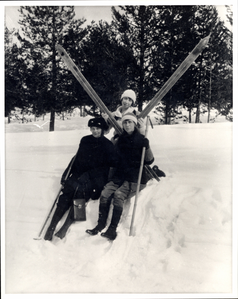 Three women skiers sitting on a snow bank