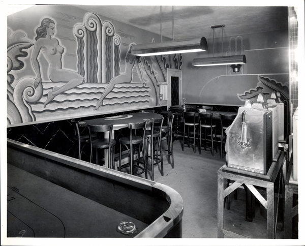 Inside of the Yacht Club in the gaming room, in view stools, mural, and slots