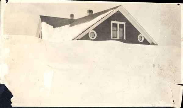 A house buried in snow all the way to the second floor