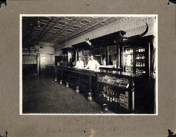 Inside of Blackwell’s Bar. On the bottom is written, “Bar hops, Bob Wilson and Chet Stevens. Blackwell’s Bar 1913-’14-’15.”. Image contains the text: "Bar Hops Ned Wilson Chet Stevens Blackwells Bar 1913"