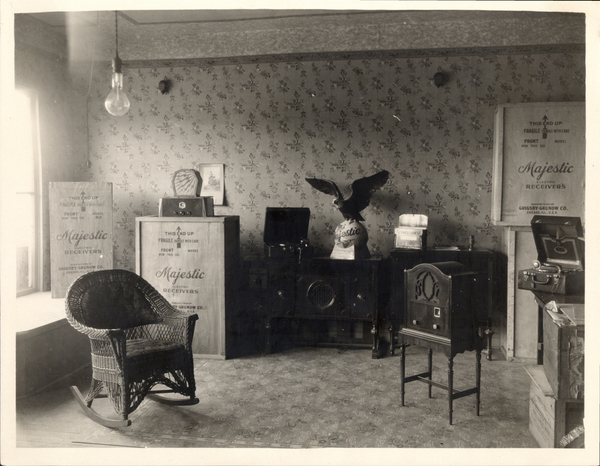 Interior view of a building on back written, “May be an interior view of Gorton store in Cascade.”. Image contains the text: "This end up   Fragile   Handle with care   Front   Model   Majestic   ReCeivers   GrigsbyGrunow Co."