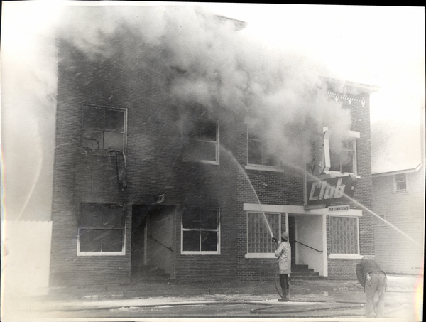 View of the Yacht Club on fire two men with fire hoses