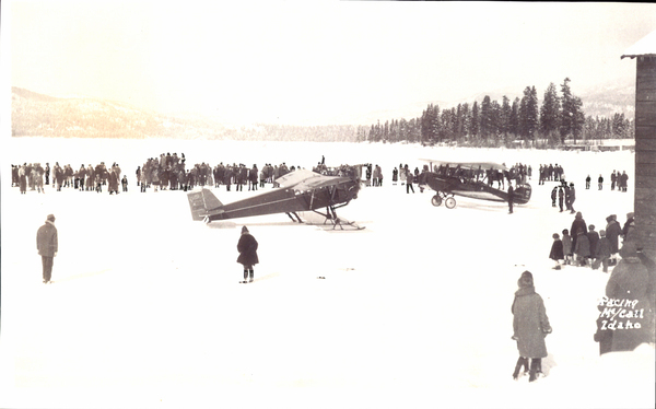 Planes on the frozen Payette lake and a crowd gathering around them. Image contains the text: "McCall   Idaho"