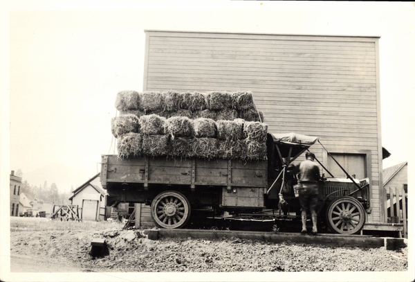 Truck loaded with hay bales and one man