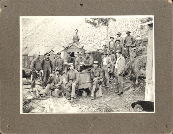 Large posed group of miners by mine