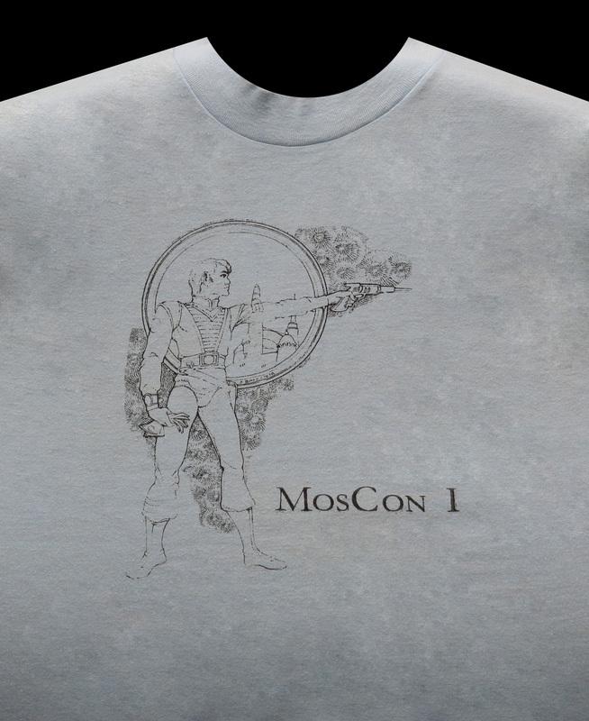 The official MosCon I shirt, featuring an image of a man shooting a laser gun.