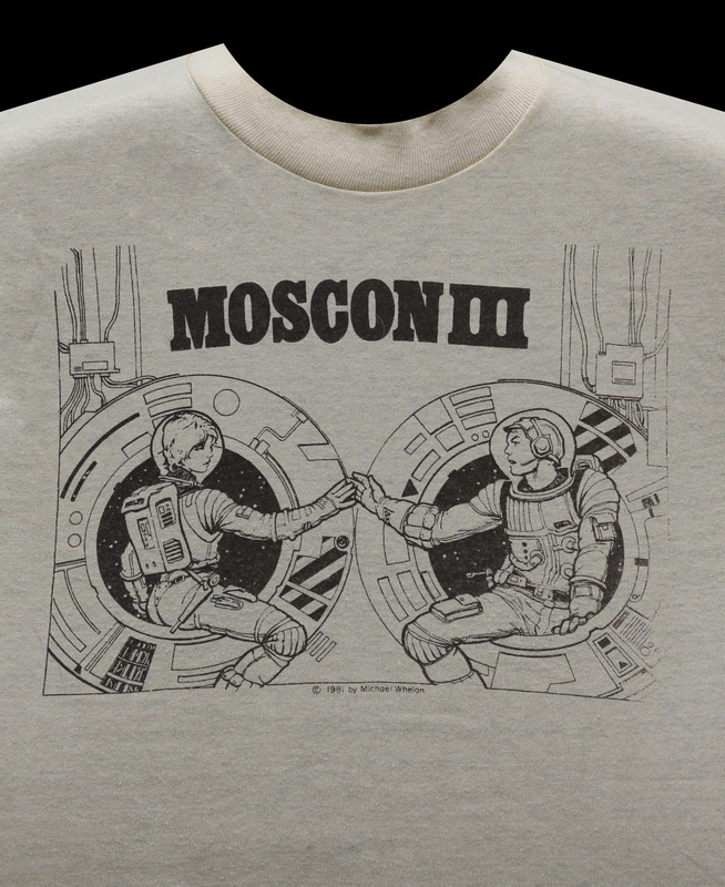The official MosCon III shirt, featuring an image of two astronauts in a spaceship touching hands in a way reminiscent of Michelangelo's "Creation of Adam."