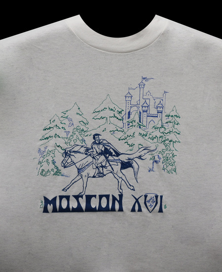 The official MosCon XVI shirt, depicting a man in a cape riding a horse in front of a castle. The shirt was manufactured by Chameleon Products in Moscow, ID, and was screenprinted using thermochromatic ink that changed color based on temperature.