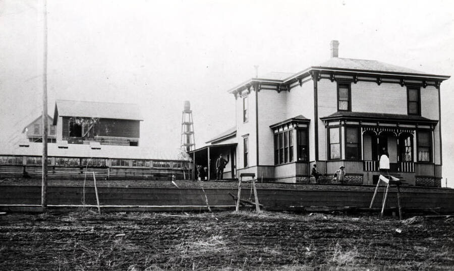 Frank Gano residence and greenhouse in the 1890s. Location not known. Later [Gano] built a home on the east side of the south Main Street hill. Left to right: Frank Gano, Ward, Myrtle, and Mrs. Gano. Gano owned and farmed a large farm three-and-one-half miles south of Moscow on Highway 95.