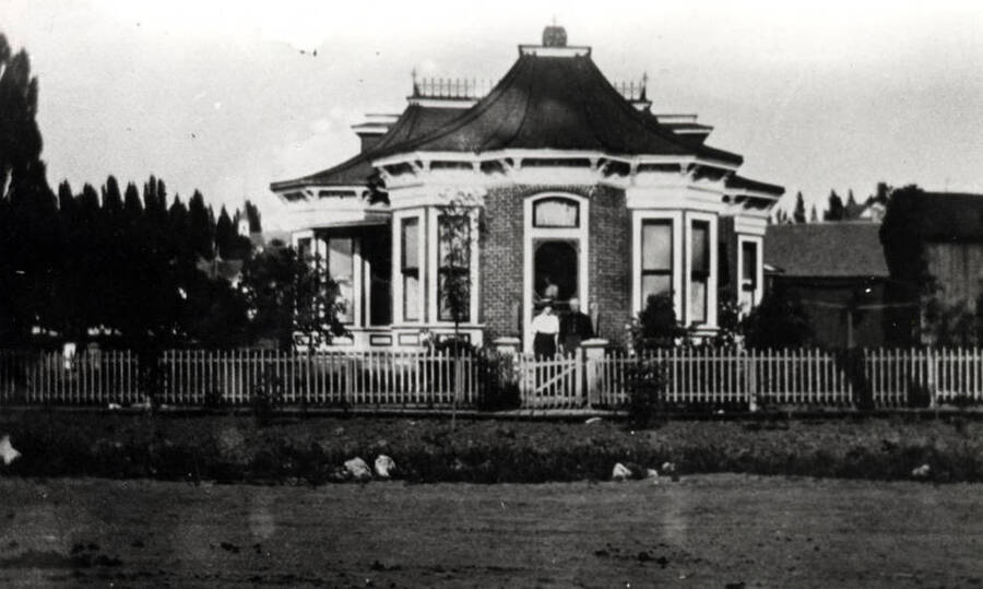 Bremer residence believed to be the first brick home built in Moscow. Located at the southeast corner of Fifth and Washington streets. Bremer lost everything during the depression of 1893. Tom Tierney purchased the home and is shown in the front yard with his wife.
