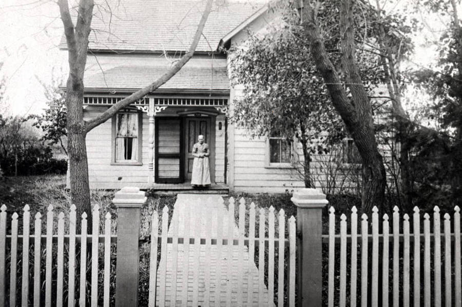 John Lundquist residence built in 1890 at 713 East Seventh Street. Mrs. Mary Lundquist standing on porch.