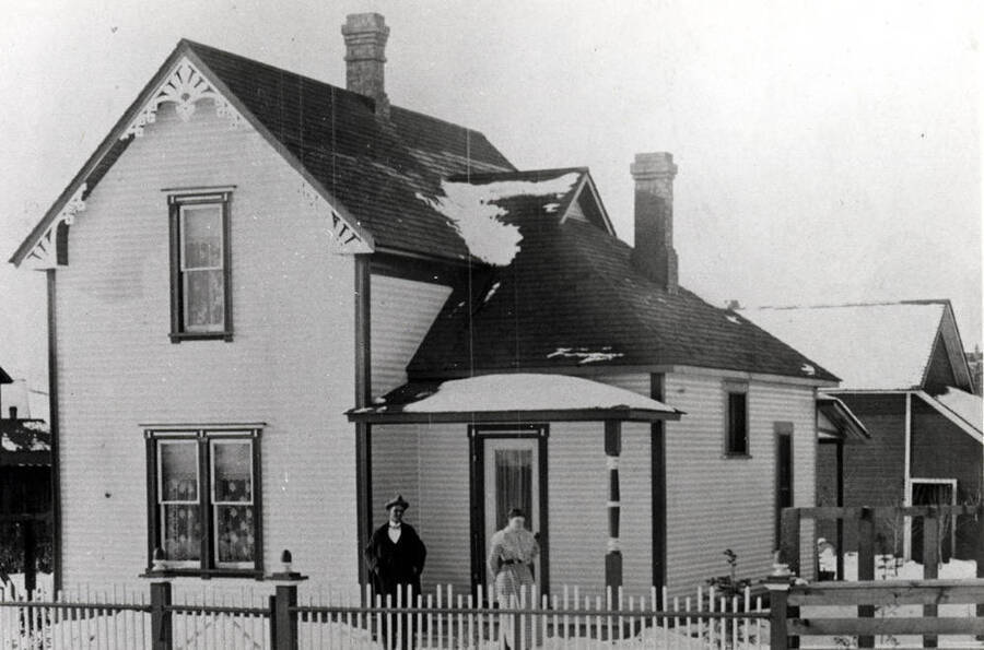 Mr. and Mrs. Simmons residence built about 1896 at 817 South Jefferson Street. Tower of the first University of Idaho Administration Building at [arrow].