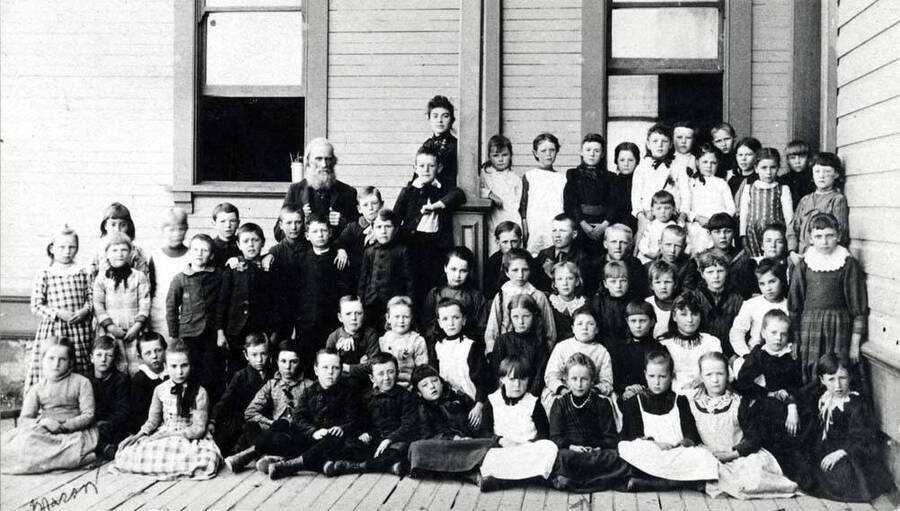 Russell School after four rooms were added in 1888-89. At this time John Russell was the janitor and Mary Shields the teacher. Arrows point to students Mason and Lula Cornwall.