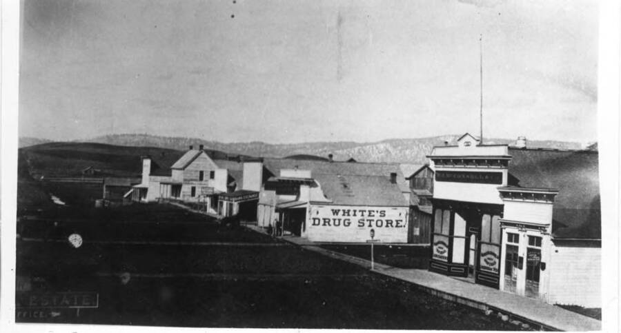 First building on right, Justice of the Peace; next, W.J. McConnell department store, southeast corner Main and First streets; White's Drug Store, northeast corner of Main and First streets; Exchange Bank, Commercial Hotel, and Fries Brewery, northeast corner of Main and A streets.