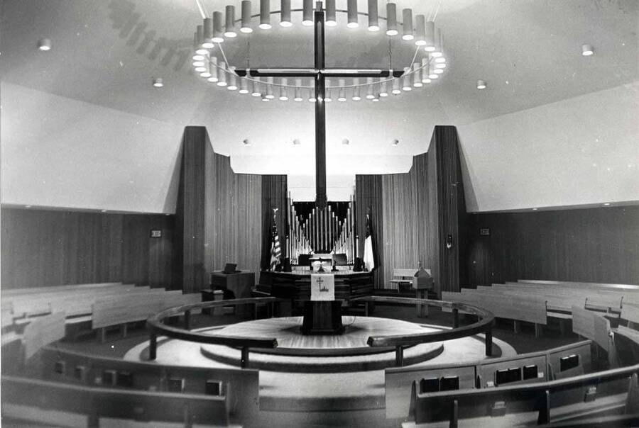 Inside Emmanual Lutheran Church showing the circular seat arrangement, the altar under the circular ceiling lights and the pipe organ beyond. Picture by Clifford M. Ott, May 6, 1981.