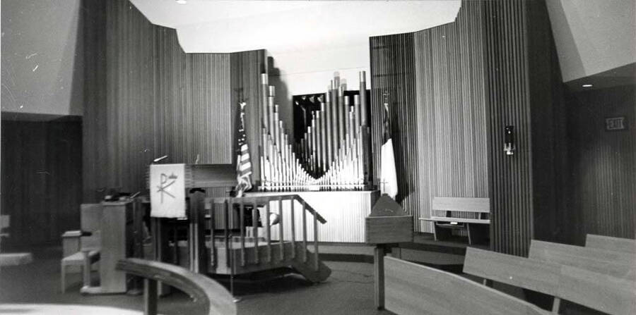 Inside Emmanual Lutheran Church showing the circular seat arrangement, the altar under the circular ceiling lights and the pipe organ beyond. Picture by Clifford M. Ott, May 6, 1981.