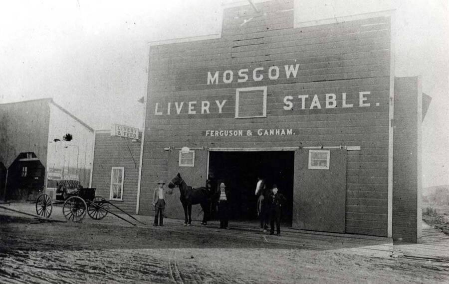 Moscow Livery Stable. Southeast corner of Fourth and Jackson streets. Left to right: James French, unknown, Cannom, and Walter French. First known as The Red Front, J.M. Fuller, Proprietor. 1890s.