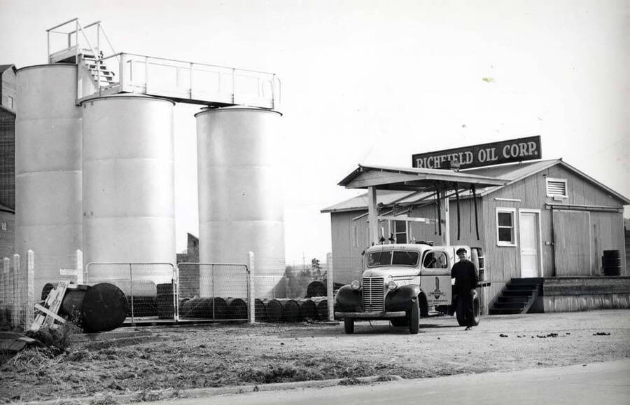 East side of Main Street north of the railroad tracks. Richfield Oil Corporation bulk plant. Washburn-Wilson Seed Company warehouse left.