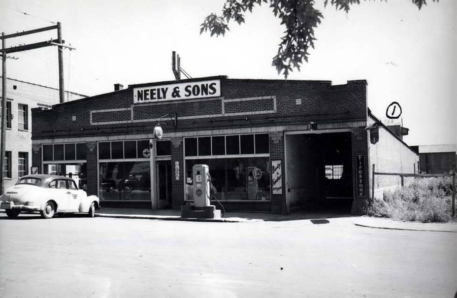 South side of Fourth Street between Main and Jackson streets west of the alley. Neely & Sons, Hudson dealer. (1) top of the Washington Water Power sub-station, all metal building. Both buildings razed for the city parking lot.