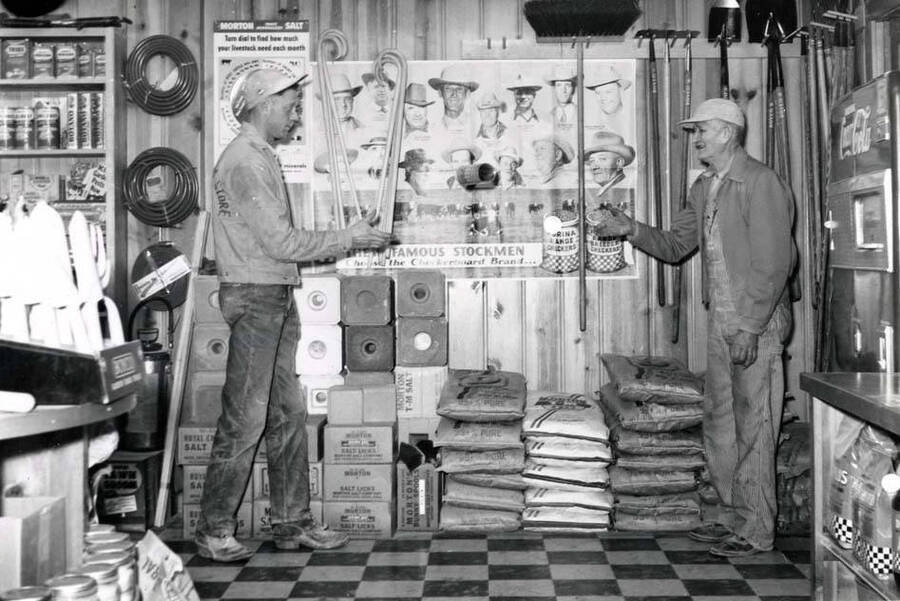 Clem Russell, left, and Ed McGuire, feed processors for Washburn's Farm Store, playing catch with a Purina bottle. When Clifford M. Ott left the store in July of 1960, Clem was manager for several years.