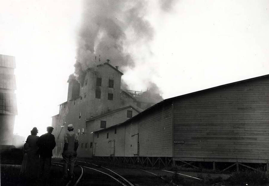 Looking northeast up the railroad tracks at the Washburn-Wilson Seed Company fire from Asbury Street, July 7, 1945.