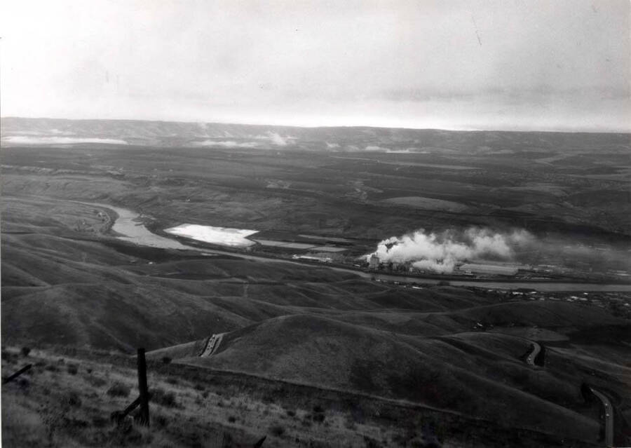 Looking southeast from the viewpoint top of the old Lewiston Grade showing Potlatch Lumber Company and light area, their settling pond.