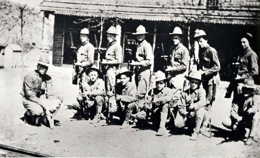 Riparia detachment of Co. F 2nd Idaho Infantry in front of hotel. Left to right, standing: Hubble, Gustafson, Johnston, Whittaker, Jameson and Foote. Left to right, front: Corp. Ott holding the detachment mascot 'Billy,' Gage, Johnson, Ferguson, Wooley and Vanairsdale. Not in picture: Stillinger, Shapley, Kellar, Starnes, Post, and Phillips. Whittaker and Jameson killed in action.