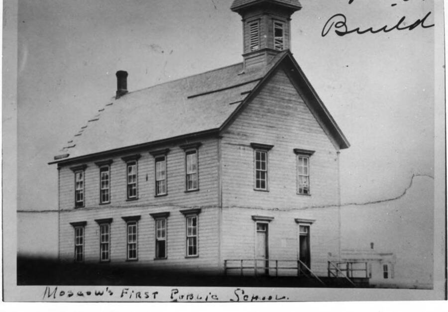 Moscow's first public school, Russell built 1884, located center of block between First and A streets and Jefferson and Adams streets. Note the building at the right-hand corner of picture was [the home of] one of Moscow's pioneer doctors, Dr. W.A. Adair. His home is still there 1968.