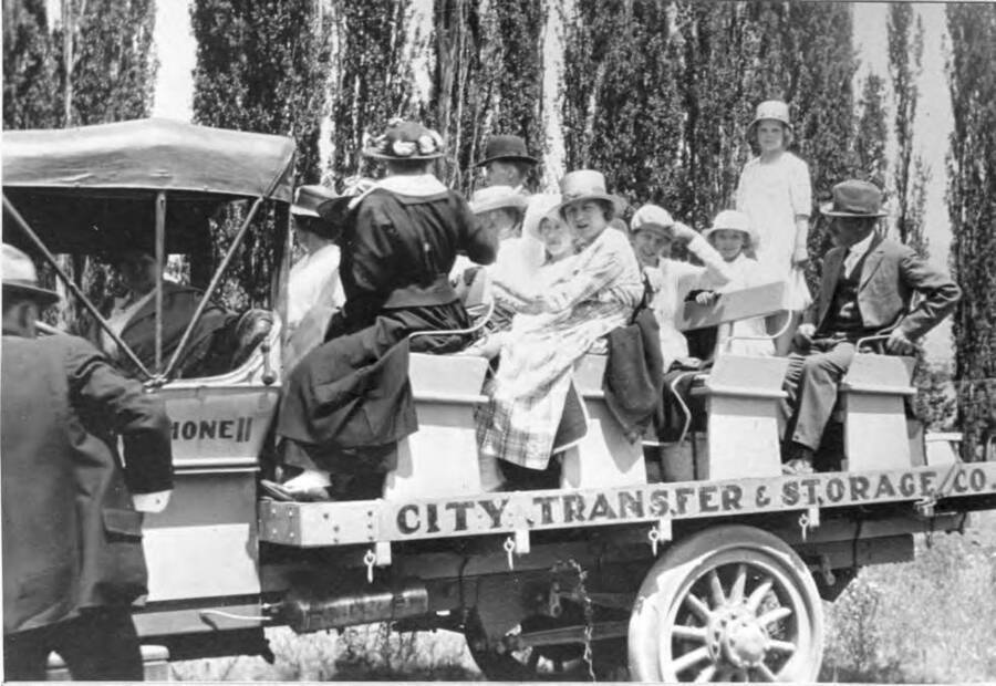 Carl Smith's City Transfer & Storage Company truck equipped with seats to haul passengers to  picnic areas. Smith was fire chief of the Moscow Fire Department for many years. Smith at left. 1920s.
