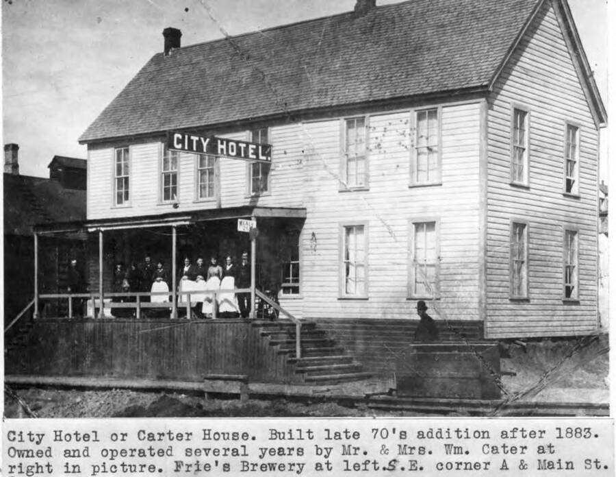 Built late 1870s, addition after 1883. Owned and operated several years by Mr. and Mrs. William Carter at right in picture. Frie's Brewery at left, southeast corner of A and Main streets.