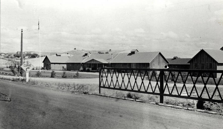 Looking northeast at the Civilian Conservation Corps camp in 1934 located at the southeast corner of the junction of Highway 95 and South Palouse Creek Road about one mile south of Moscow. Picture was taken from the bridge across the South Palouse Creek on Highway 95. Long building at the right is the Chinese Village as of 1977. Picture from Jerry Kimes.