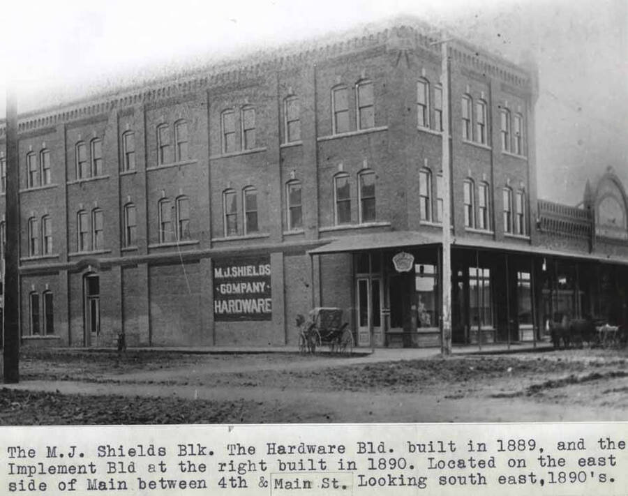 The hardware block built in 1889, and the implement building at the right built in 1890. Located on the east side of Main between Fourth and Main streets. Looking southeast, 1890s.
