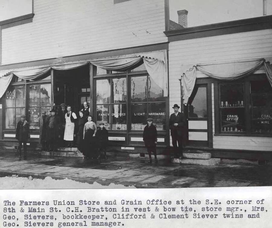 At the southeast corner of Eighth and Main streets. C.H. Bratton in vest and bow tie, store manager; Mrs. George Sievers, bookkeeper; Clifford and Clement Sievers, twins and George Sievers general manager.