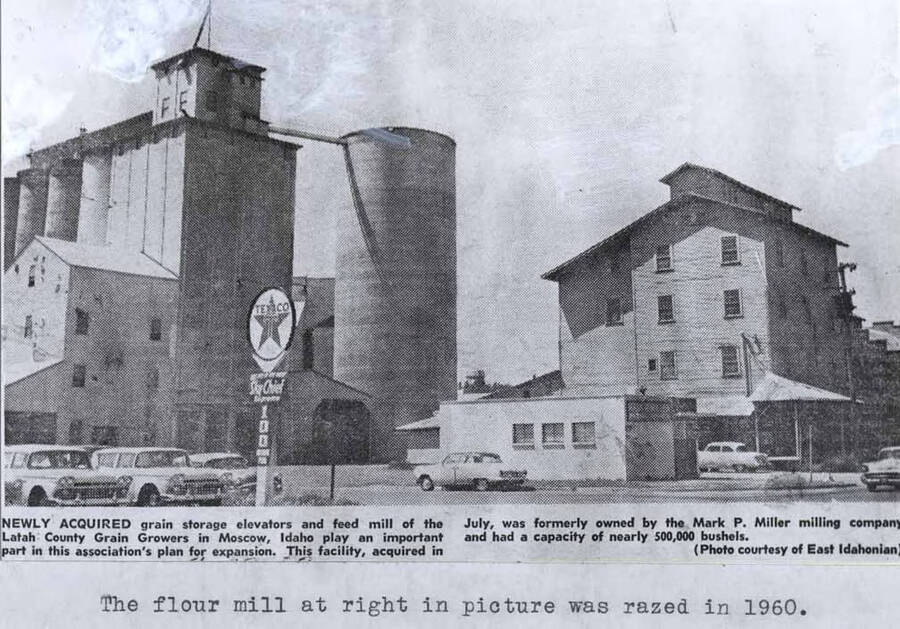 Photo of newspaper photo. Caption: "Newly Acquired grain storage elevators and feed mill of the Latah County Grain Growers in Moscow, Idaho play an important part in this association's plan for expansion. This facility, acquired in July, was formerly owned by the Mark P. Miller milling company and had a capacity of nearly 500,000 bushels. (Photo courtesy of East Idahonian." The flour mill at right in picture was razed in 1960.