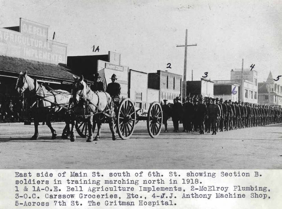 South of Sixth Street showing Section B soldiers in training marching north in 1918. 1 & 1A- O.E. Bell agriculture implements, 2- McElroy plumbing, 3- O.C. Carssow groceries, Etc., 4- J.J. Anthony machine shop, 5- Across Seventh Street, Gritman [Memorial] Hospital.