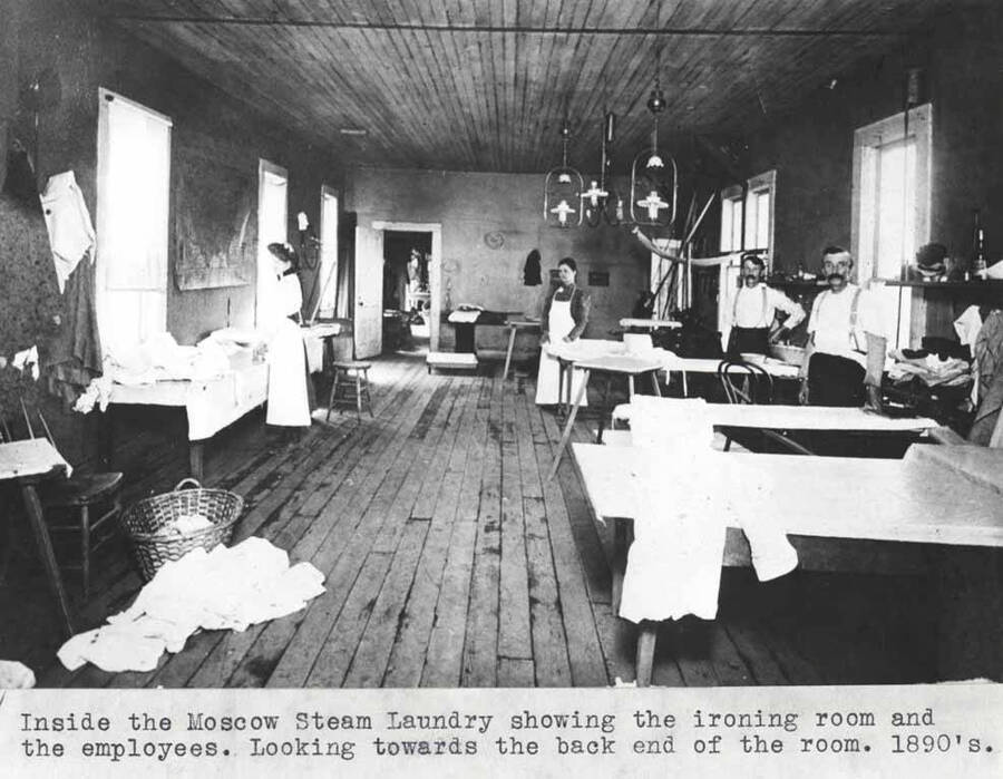 Showing the ironing room and the employees. Looking towards the back end of the room. 1890s.