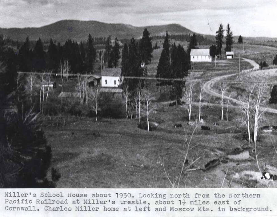 About 1930. Looking north from the Northern Pacific Railroad at Miller's trestle, about one-and-one-half miles east of Cornwall. Charles Miller home at left and Moscow Mountains in background.