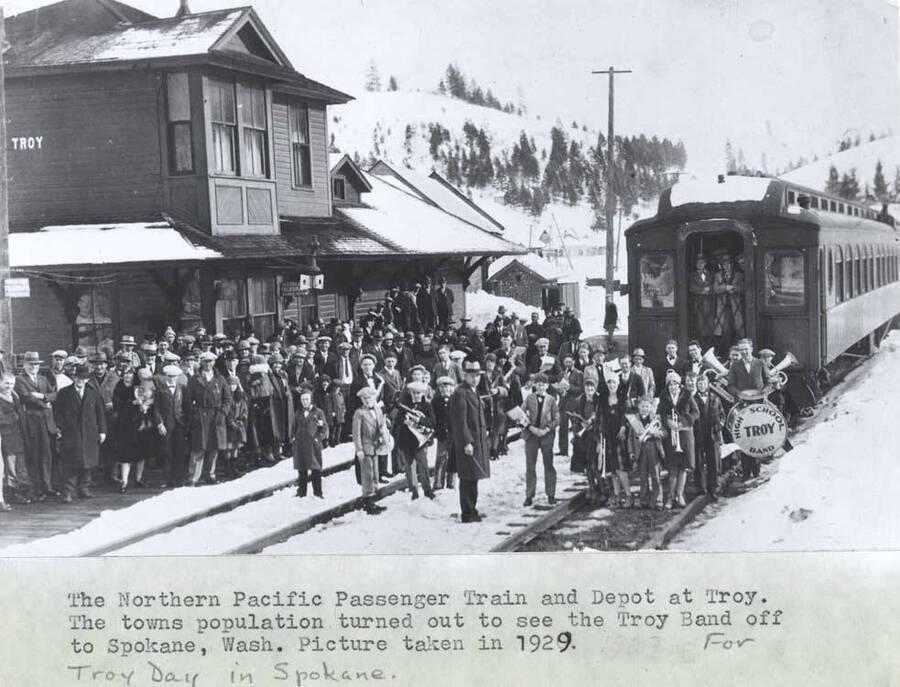 The Northern Pacific [Railroad] passenger track and depot at Troy. The town's population turned out to see the Troy Band off to Spokane, Washington. Picture taken in 1929. For Troy Day in Spokane.