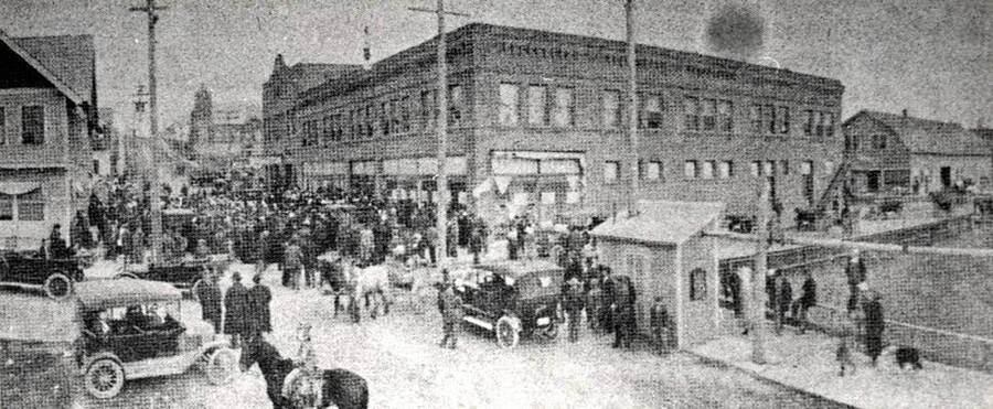 [Photo of newspaper article] Caption: Downtown Potlatch on one of the company store sales days in early 1910s. Beyond store in center is company bank, above which, in lodge hall, shoppers enjoyed free lunches. The Union Protestant Church is on up the street. Hotel is at left, farm implement store at right.