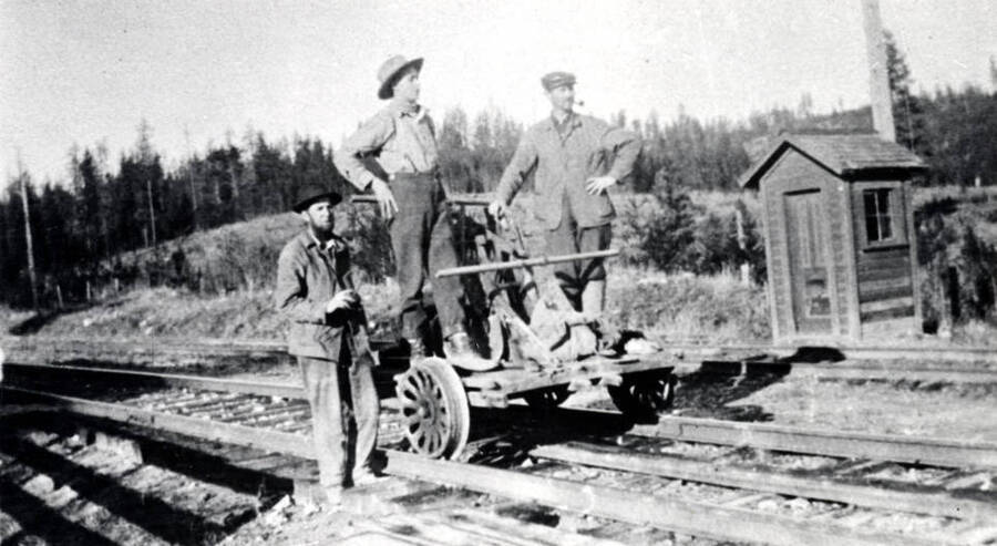 Located on the Washington, Idaho, Montana Railway northwest of Avon. Shows three men and hand car on track.