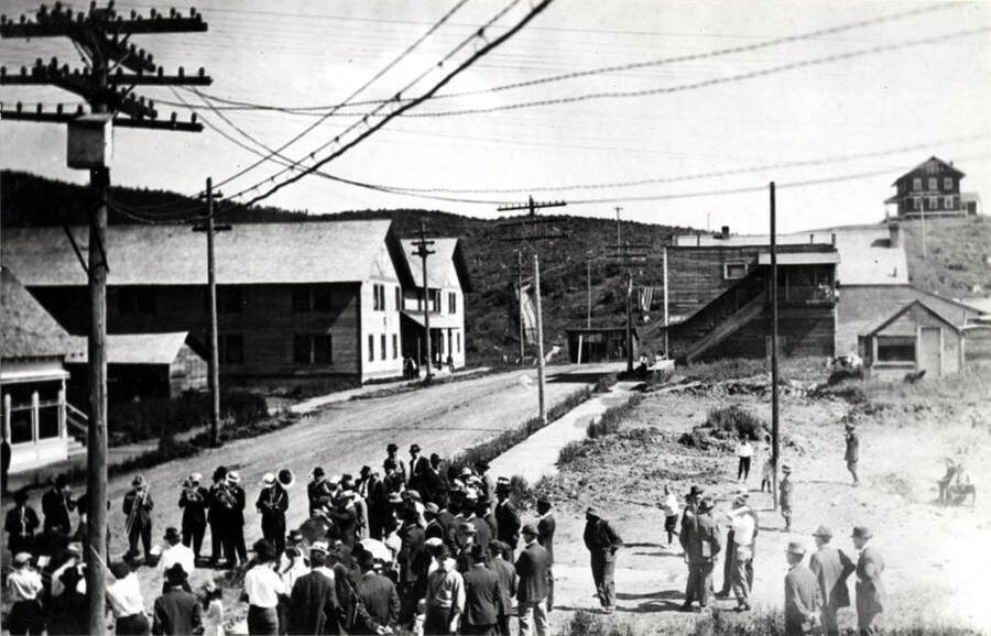 Playing on Sunday on Main Street. Large building at left was the boarding house (burned). Hospital is seen on hilltop at right in picture. 1920-1921.