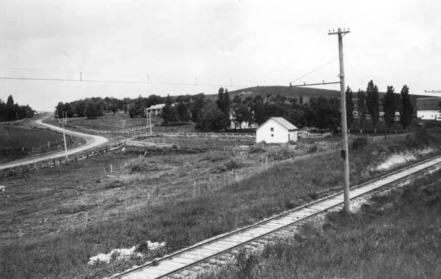 Gub Mix home top, Frank Mix home at right. Mix barn extreme right. North-south highway at left and the Spokane & Inland Electric Railroad in foreground. Picture about 1910.