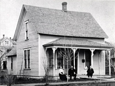J.R. Strong residence built in the 1890s or early 1900s. Left to right: Mrs. Mary M. Strong, Mr. J.R. Strong and James Harvey Putman, brother of Mrs. Strong. Picture 1912-1913. 412 East Spotswood Street.