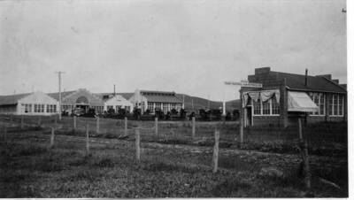 Idaho National Harvester Company buildings built in 1911 west of Main Street between D  and E streets near the Spokane & Inland Electric railroad tracks. D Street in foreground and office at right. Now site of Rosauer's, Drug Fair, and Yellow Front. From Main Street west to paved parking area as of 1977.
