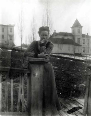 Looking east across Jefferson Street at two of Moscow's schools. Irving at the left and Russell at the right. Small annex in front of Russell was believed to have been used as a school before Russell was built. Mrs. W.A. Lauder, Alma Lauder Keeling's mother, in the foreground. Picture after 1901 and before 1912.