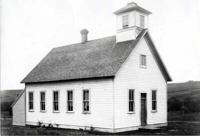 Typical country school of the early 1900s located south of the Moscow-Pullman Road and west of Sunshine Road. Looking northwest with Paradise Creek covered with brush. Picture about 1906.