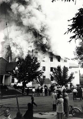 Looking northwest from the intersection of First and Almon streets at the Washburn-Wilson Seed Company fire of July 7, 1945. Virginia Ott Pitkin with bicycle.