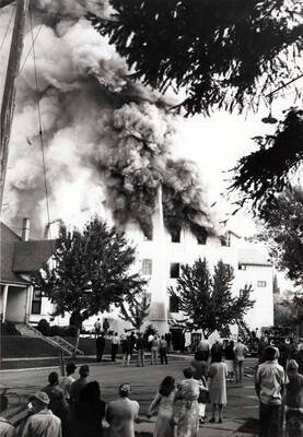 Looking northwest from the intersection of First and Almon streets at the Washburn-Wilson Seed Company fire of July 7, 1945. Virginia Ott Pitkin with bicycle.