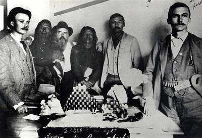 Cashing U.S. government checks for Nez Perce Indians at the Indian Agency, Lapwai, Idaho, August 15, 1895. Total amount of first payment $626,222.00. Each Indian received $302.96. Balance of $1,000,000 was to be paid in ten annual installments. Photograph taken at the Indian Agency at Lapwai, Idaho, 14 miles east of Lewiston, during the payment. Persons in picture, left to right: Fred Bremmer, Kendrick; Three Feathers (Mah-tot-wap-tus); Sam Martin, clerk at Agency; Red Horn (Teh-was-in-pilpt); Eddie Conner, half-breed, interpreter at Agency; J. Howard Howe, representing Lewiston National Bank of Lewiston, Idaho.